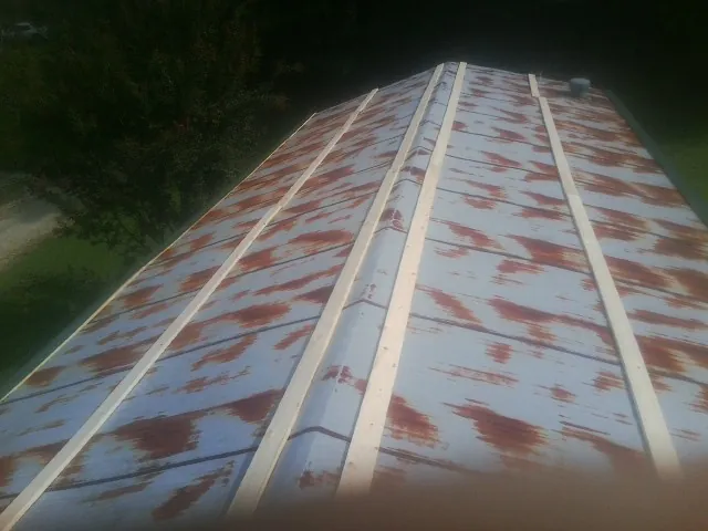 Rusted metal roof panels with new wood purlins before replacement — Storm Damage Roof Repair in Santa Fe by Roofing Brothers